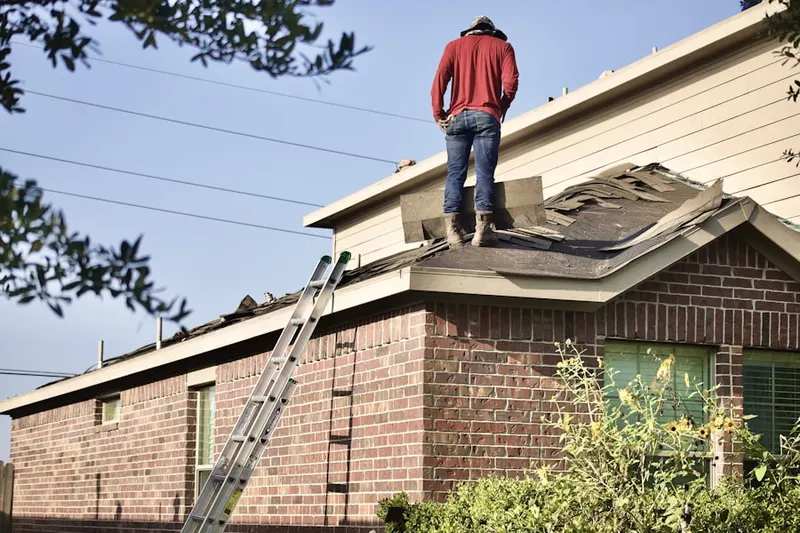 Professional roofer working on a residential roof in Worth